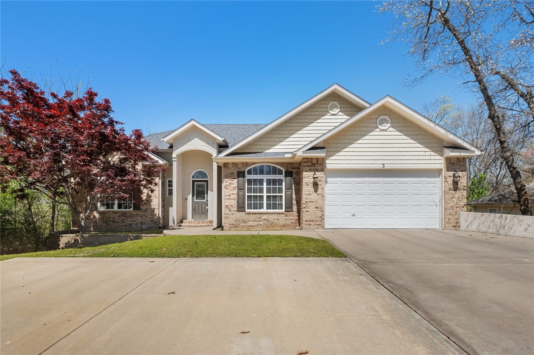 Welcome to 3 Rutland Drive in Bella Vista! This charming home features the primary bedroom upstairs & then the 2 secondary rooms are both downstairs, along with additional living space downstairs, a small kitchen area, & a game room/living area. Enjoy luxurious details like granite countertops, crown molding, & a custom fireplace. The open floor plan leads to a covered patio & 2 large decks, perfect for entertaining. The master suite boasts a double sink vanity, walk-in closet, whirlpool tub, & luxury shower. Extras include spacious bonus room, a laundry room sink, & a brand new roof. Located within walking distance of Lake Brittany & close to Metfield Center. Enjoy community amenities such as the boat dock, club house, exercise room, park, playground, pool, rec room, spa//sauna, & tennis court!