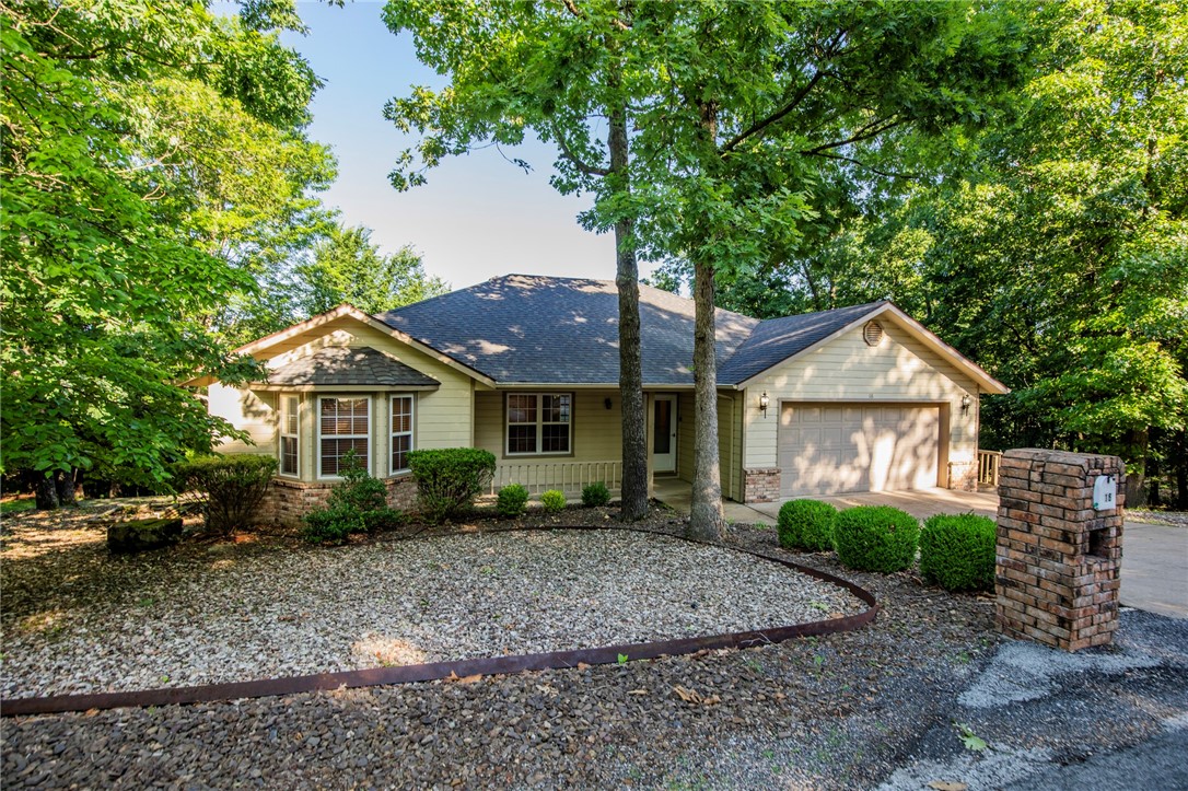 Welcome to 16 Penrith Drive — a meticulously maintained, one-owner home nestled in a serene Bella Vista setting and zoned for sought-after Bentonville Schools. This 3-bedroom, 2-bath home offers flexibility with an ideal office space or optional third bedroom. Enjoy the spacious layout featuring walk-in closets, a large living area, and a functional kitchen with classic Formica countertops. Recent updates include a new roof (2020) and HVAC (2019), providing peace of mind for years to come. The backyard is a private retreat, perfect for relaxing or entertaining, and a bonus workshop/storage area beneath the home offers added versatility. Located in a quiet neighborhood with convenient access to trails, lakes, and golf. Ready for your personal touch — come see the potential!