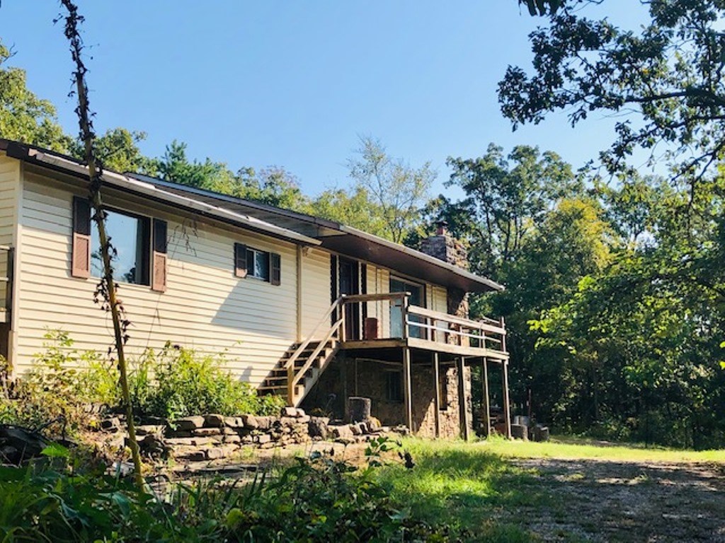 FRESH & CLEAN REMODEL on 7 wooded acres! NEW HVAC, SEPTIC, LAMINATE FLOORING, PAINT, SUMP-PUMP, ELECTRICAL PANEL, ROOF, GUTTERS & MORE. Family room has large stone fireplace; "Other" room has vintage wood-cookstove. Established, fenced gardens, covered deck with view, basement workshop. 2017 survey; small wildlife pond. Less than 2 miles to Interstate on paved road! Some handicap-features. Frig, propane tank, woodstove, W/D, & firewood convey with full-price offer.
