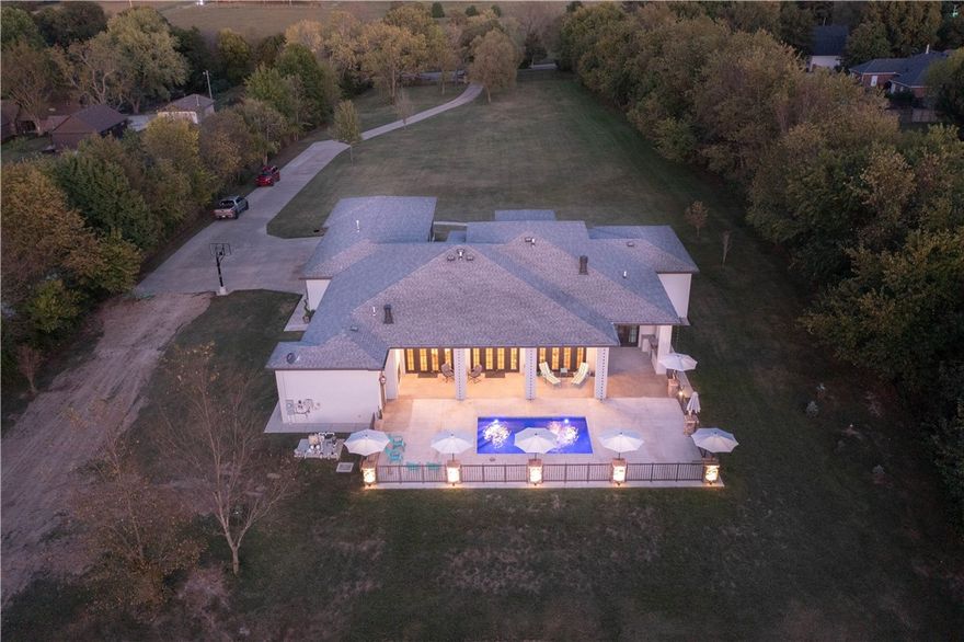 This single-owner home sits on a prized 6-acre lot with mature trees along the perimeter. Secluded and centrally located at the heart of NWA. The inside features an open concept with 12 feet of custom cabinetry, stainless steel appliances, along with a 16’x4’ granite countertop island. Exercise and office rooms lay catty-corner to the living area. Oversized master bath with his/hers and extra walk-in closet. The spacious 12-foot ceilings are complimented by 8-foot doors throughout, complete with a floating hardwood floor. An abundance of natural light is present as a result of the numerous windows, and most notably, the 12 sets of windows in the living room with 3 sets of French doors included. Back patio is covered with a 1-year-old inground pool and outdoor built-in grill. Tucked in between Wagon wheel and Elm Springs Rd, it is a 5-minute drive to Macadoodles, Walmart, as well as I-49, allowing for quick access to XNA and all of NWA’s main locations. Video Tour: https://www.youtube.com/watch?v=5HeDrUyNkT8