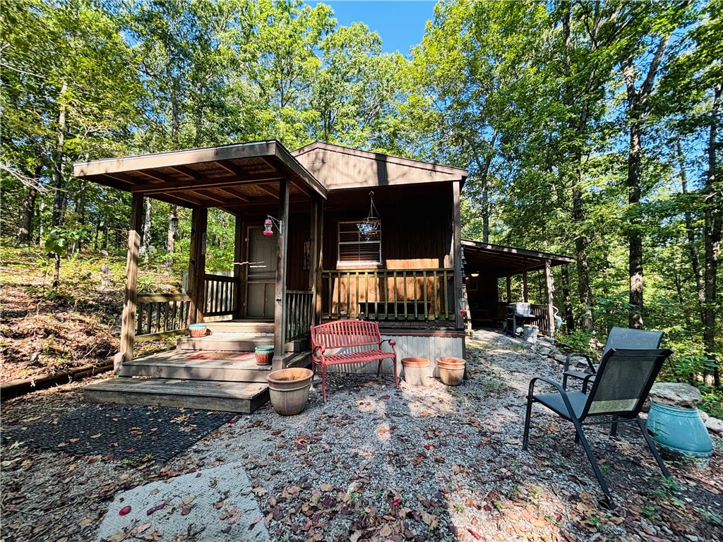 Tucked away on 3.62± wooded acres, this handcrafted one-bedroom cabin feels like a true Ozarks hideaway. Unique craftsmanship runs throughout, giving the home a warmth and character you won't find in a cookie-cutter build.
Experience the best of off-grid living with the convenience of city water delivery by Water Wagon and an electric pump that provides water to the homeāpractical comfort without sacrificing the retreat feel. Step outside to a covered porch or patio where mornings begin with birdsong and evenings end under the stars.
Two shedsāone wired with electricityāplus a detached carport provide ample space for tools, toys, or hobbies. And with CCC access to Bull Shoals Lake less than two miles away, you'll enjoy easy days of fishing, boating and exploring. With no restrictions and an off-grid setting, this property embodies the free-spirited lifestyle it offers. Will not go with VA, RD, FHA or Conventional Loans.