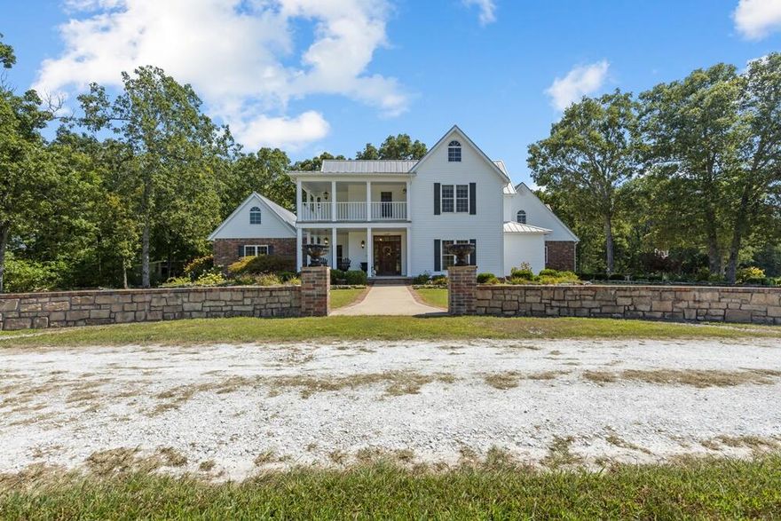 This elegant 4,400 sq ft farmhouse-style home sits on 21.5 acres with breathtaking Ozark Mountain views, just 5 miles from Harrison. Built 18 years ago, it's in pristine condition, offering 3-4 bedrooms (bonus room as a 4th), 2.5 baths, 2x6 walls, 9 ft ceilings, large windows, crown molding, and ash and hickory hardwood floors. The living room features a gas fireplace, while a wood stove warms the glassed-in sunroom. The eat-in kitchen is a chef's dream, with stainless steel appliances, Silestone quartz countertops, and a spacious pantry. The main level includes a formal dining room, den, and a luxurious master suite with an office, dual walk-in closets, and a modern bath with heated tile floors, a soaker tub, double vanities, and a walk-in shower.