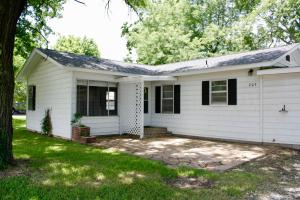 NOW INCLUDES 1.03 ACRES! Steel sided 2 bedroom home. Oversized 2 car garage has inground storm cellar inside. Large tree shade ACRE. Laminate and tile floors. Deck overlooking your backyard. Large natural stone patio in front. NEW ROOF as well as insulation added in attic, efficient heat pump for heating and air conditioning. This house sits just on the outskirts of city limits with a gorgeous back yard, but you are minutes from downtown and very close the interstate for easy commutes to work.