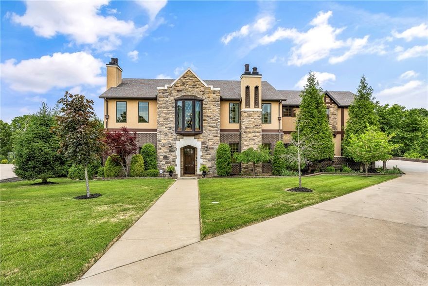 Gorgeous 5250 sq ft custom Tudor home full of old world charm with modern upscale amenities. Soaring 22' ceiling in kitchen, breakfast, and family room. 6 x 9 island with copper apron sink and 2 dishwashers. 6-burner gas stove with griddle. Breathtaking woodwork and details throughout. Multiple outdoor entertaining options overlooking a stunning saltwater pool with copper waterfalls. Outdoor kitchen, outdoor shower. Every bedroom has a private bath. Home was featured on HGTV. All of this sitting on gorgeous 1.5 acres of secluded property, all in the convenience of Fayetteville, close to I-49, U of A, the NWA Mall area, and more. Drapes in the great room do not convey.