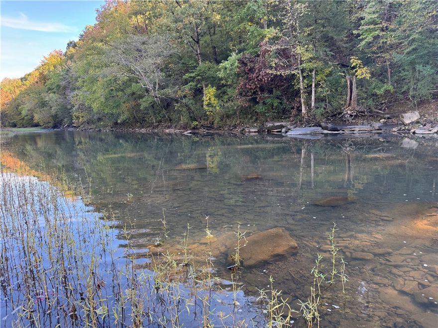 Breathtaking buildable acreage along Frog Bayou featuring river access, stunning panoramic views, and mature hardwood and pine timber. Enjoy paved road frontage with electric and rural water available. Located between Fayetteville and Fort Smith, just minutes from I-49. The property is loaded with wildlife, offering abundant deer sign, rubs, and scrapes. Perfect for building your dream home, a hunting retreat, or a long-term investment in a peaceful, natural setting.
