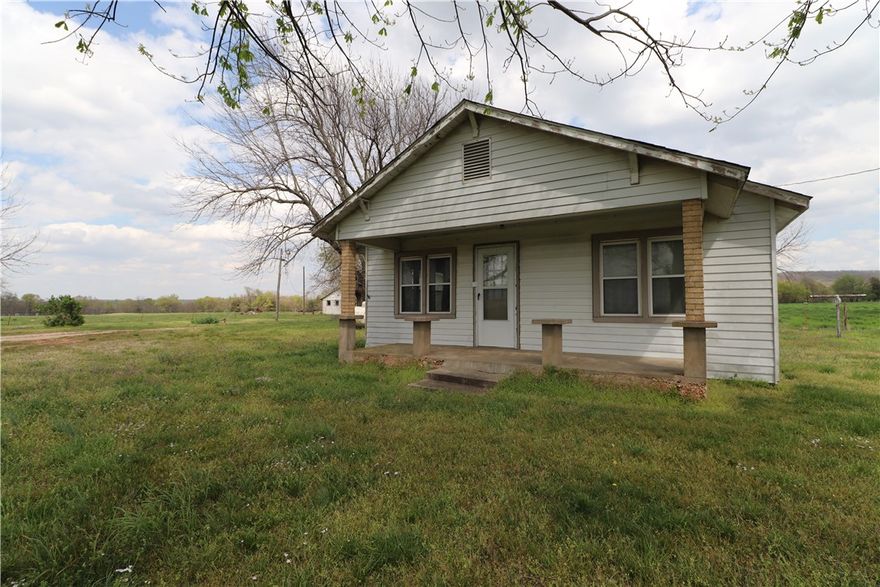 Beautiful 100.81 +/- acres on pavement with all utilities except sewer. This farm is approximately 85% pasture and mostly level. 2 bed 1 bath 858 SQ FT farm house needs repairs but offers original hardwood floors, updated windows, 10X26 framed in back porch, 24x30 detached 2 car garage, and a storm shelter. Other improvements on this property include a 40X62 insulated shop with water and electric, an old hay barn, and 2 old block barns. There is a large double pond and a smaller pond. This property is ready for livestock and is fenced and cross fenced. Waterers, dedicated hay fields, and a wet weather creek. Also listed as farm MLS #1180083. Agent Owned