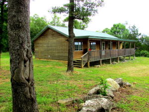 Beautiful panoramic views of the Ozarks Hills from the over-sized front porch of this log-sided home with 3 bedrooms and 2 full baths. Are you someone looking for privacy, acreage to hunt, or the serenity of the quiet? This home is near Bull Shoals Lake and boat ramp for that perfect oasis or full-time living all while enjoying the deer, turkey and wildlife. Outbuilding is provided for extra storage and back deck is perfect for entertaining. Handyman will enjoy renovating or homeowner will be able to personalize and make it their own cabin in the woods!