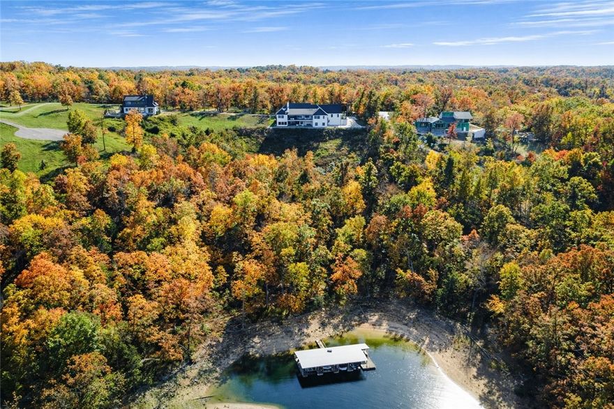 Experience lakefront living in this 2024 custom Beaver Lake retreat, with one slip in a 4-slip dock & breathtaking panoramic views. Walls of glass frame the water, while a dramatic wood-burning fireplace anchors the open-concept living space.The luxury kitchen features premium finishes, designer appliances, and a walk-in pantry with direct garage access. A stunning 1,327 sq ft covered deck offers remote screens, heat lamps, an outdoor grill, and a second wood-burning fireplace—your private outdoor living room overlooking the lake. The main level includes a private primary suite, three additional bedrooms, two full baths, laundry, and a half bath. The walk-out lower level delivers a resort-style experience with a golf simulator, gym, wine cellar, safe room, and private ADU with two bedrooms, full kitchen, and bath—ideal for guests or income potential.Complete with a private pickleball court, hot tub, fire pit, oversized epoxy-floored garage, workshop, and storage, this rare offering defines luxury lakefront living.