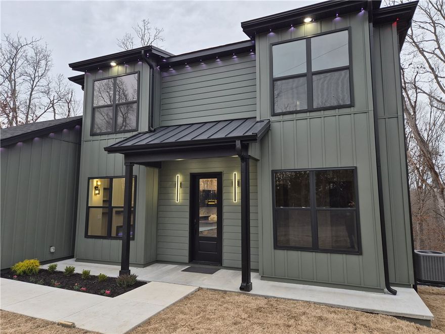 Contemporary new construction designed for modern living and everyday functionality. This 3-bedroom, 2 full + 1 half bath home is a great family option with two living areas and two laundry rooms—one on each level for added convenience.

Built with 2x6 framing and blown cellulose insulation for efficiency and comfort. Exterior features Alside Ascend composite siding with the look of wood, low maintenance, and long-term durability.

Inside offers 10-ft ceilings, solid-core 8-ft doors, LVP flooring, and a bright open layout. The designer kitchen includes custom slim Shaker cabinets, quartz waterfall island, gold hardware, full-height backsplash, pantry, and coffee bar.

Primary suite features a double vanity and floor-to-ceiling tiled shower with glass enclosure. Upstairs includes a flexible second living area. Covered composite deck overlooks wooded views.