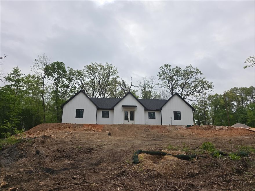 Modern farmhouse new construction at 46 Northfleet Ln, Bella Vista—crafted by a 30+ year experienced builder and constructed with Nudura ICF (Insulated Concrete Forms) for a noticeably stronger, quieter, and more energy-efficient home than traditional wood framing. ICF walls combine reinforced concrete with continuous insulation for steadier indoor temperatures, reduced outside noise, added durability, and lower heating/cooling demand. Scan the QR code or watch the YouTube video on ICF: https://shkd.us/QF6YiIWs

Thoughtful 2,135 SF main-level plan features an open great room + kitchen, large pantry, mudroom, laundry, and a private primary suite with walk-in closet and spa-style bath, plus Bedrooms 2 & 3 and an additional full bath. High-grade laminate flooring, granite countertops, and LG appliances throughout. Beautiful lot at end of a private cul-de-sac with side-load garage. Minutes to Back 40 trails, plus Bella Vista POA lakes, golf, and trails; close to shopping, healthcare & major NWA corridors