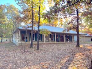 Look at this Ozark Mountain Showplace! Located near Bull Shoals Lake, one of the premier fishing and recreational lakes in Mid-America, and the White River, a renowned rainbow and brown trout fishery!This custom built home is only 8 years old and is in immaculate condition. Also included is an extra nice guest cabin, all nestled onto 117 acres. Much of the land is park-like, with large hardwood & pine trees shading the open areas. The 3 bedroom (more bedrooms could be added upstairs), 2 1/2 bath home has too many extras to list! The spacious den has a wood burning fireplace and the spectacular eat-in kitchen has granite countertops, a large island, a double oven, soft close cabinet doors, farmer's sink & much more. Formal dining room with Butler's Pantry.