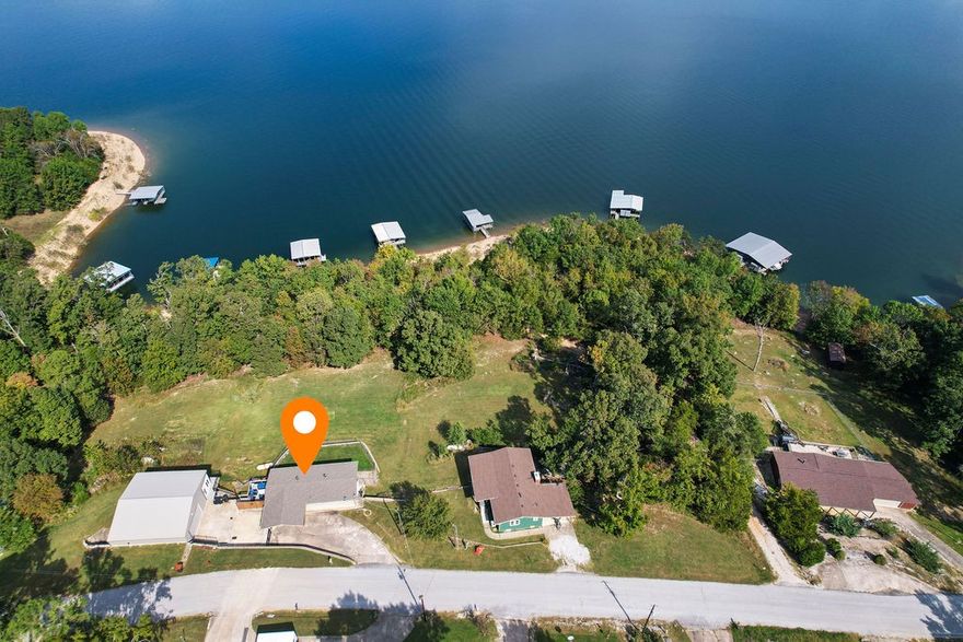 Your Beaver Lake getaway awaits! This 1,840 sq ft home offers the perfect blend of comfort, convenience, and outdoor adventure. Nestled on a scenic .96 acre lot w/direct water access, it's ideal for anyone who loves lake life, entertaining, or simply relaxing with a view. The main level offers a large kitchen w/ample storage, a half bath, & 2 living areas. Downstairs you'll find 2 large bedrooms w/sliding glass doors leading outside, washer/dryer, & a recently updated full bath. Outside, enjoy two large decks w/stunning lake views-- perfect for entertaining. The 30x40 shop is a major bonus offering space for boats, ATVs or a full workshop. It is equipped w/a pellet stove, large bar, kegerator, work benches, shelves & a plumbed room ready to be finished out as a bathroom. You will also find a 12x40 heat/cooled bonus room w/a wall of windows. Jump in your included Kawasaki Mule & drive down to your shared boat dock which includes a 10x26 slip & front mount lift w/new floats. Seller is installing new trim & painting.