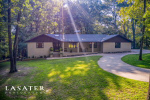 You will fall in love with this beautiful 5 bedroom 4 bath all brick home on 1.93 wooded acres in sought after Woodcroft subdivision, featuring a newly remodeled kitchen, beautiful cedar and pine accents throughout the home, and a theater room with gas fireplace. Massive 728sf back deck covers the entire length of the home. Kitchen has commercial side by side refrigerator & freezer, range is a 6 burner gas convection oven with extra side oven, top of the line super quiet dishwasher, custom pine-lined skylight, ceramic tile backdrop, built-in microwave drawer, custom cabinets & more! Check out this warm and inviting home.