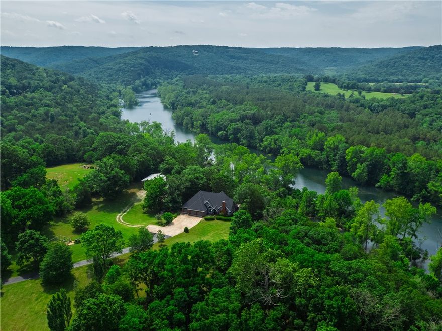 Escape to unparalleled luxury with this breathtaking 13.52-acre river-front estate offering elite panoramic river and hillside views. This 4,936 sqft retreat features 5 spacious bedrooms, 3.5 baths, and a gourmet kitchen with quartz countertops, walnut butcher block island, built-in wine fridge, and a massive walk-in pantry. The fully renovated primary dazzles with his-and-hers walk-in closets, a large tiled shower, stand-alone soaker tub, and in-floor electric heat. Entertain in style with a 2nd family room and custom wood high-end bar downstairs. A charming upstairs library nook invites relaxation. Fully gated with a paved drive, the estate boasts a new roof (2023), back-up generator, and an expanded custom deck. Finally, venture out to your 1,728 sqft barn/shop with RV/boat bays (w/ 30 AMP RV station) with new steel roof (2024). Lush landscaping, a deer-proof garden, and a water treatment system complete this masterpiece.