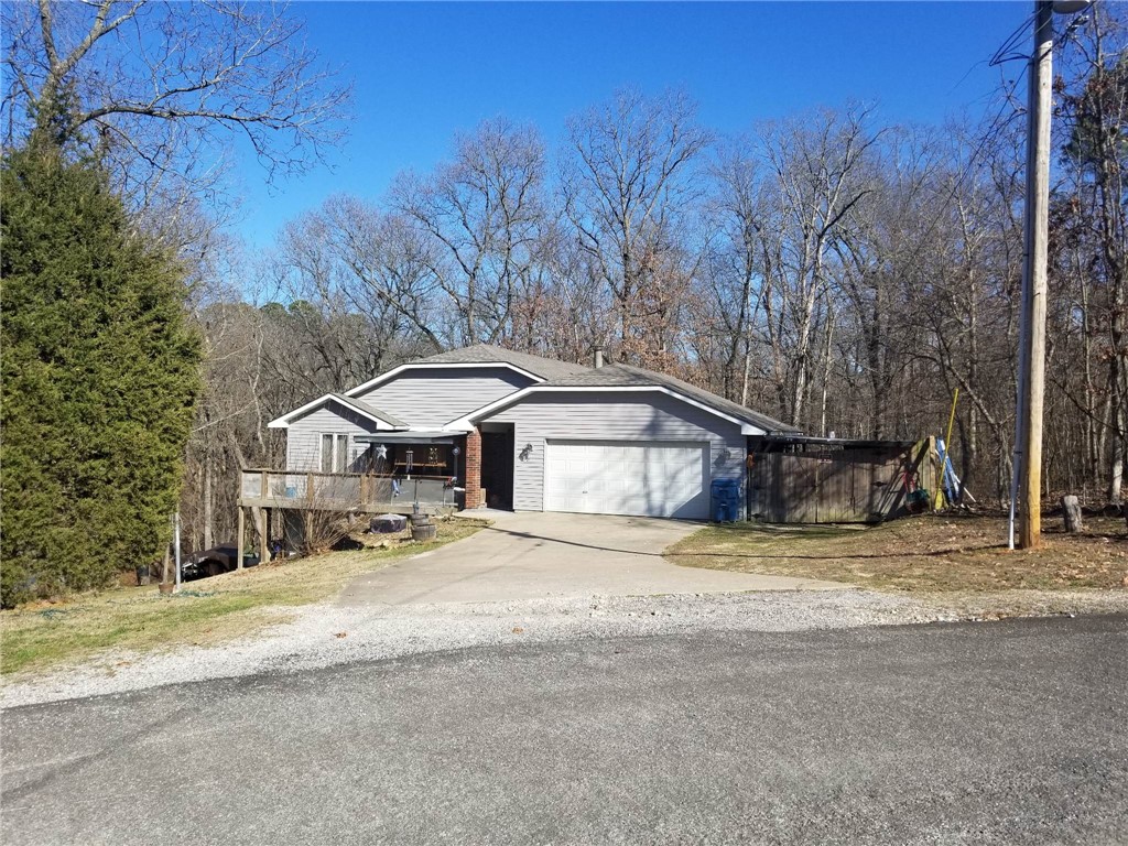 Lets make this your new home! 3 bedroom plus office that could be a fourth bedroom, 3 bathrooms, Has workshop in unfinished space under house. Wrap around deck to side yard. Larger Propane tank. 2 Primary on-suites. Corner lot. Wood burning fireplace, Bentonville schools, and easy access to highway 71. Attached boat storage behind privacy fence. Home warranty, New roof 2022. $5000 Seller concessions.