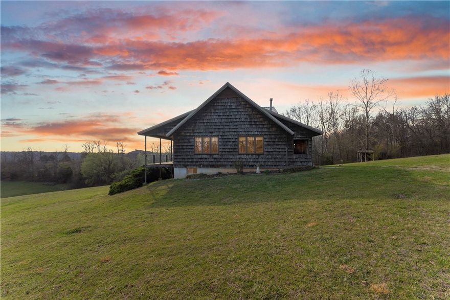 Escape to this custom-built Ozark retreat on 17 scenic acres with breathtaking views from the full-length covered deck. The home features cathedral ceilings, an open-concept living and kitchen area, and large Pella windows that bring in abundant natural light, with solid red oak throughout adding warmth and character. Built for strength with 2x6 framing, a galvalume metal roof, and a basement with reinforced poured concrete walls. A detached workshop offers space for hobbies, projects, or a future guest space, plus a pole barn for extra parking or storage. Schedule your showing today and experience the beauty and craftsmanship of this unique Ozark property.