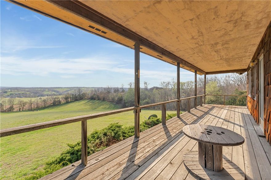 Escape to this custom-built Ozark retreat on 17 scenic acres with breathtaking views from the full-length covered deck. The home features cathedral ceilings, an open-concept living and kitchen area, and large Pella windows that bring in abundant natural light, with solid red oak throughout adding warmth and character. Built for strength with 2x6 framing, a galvalume metal roof, and a basement with reinforced poured concrete walls. A detached workshop offers space for hobbies, projects, or a future guest space, plus a pole barn for extra parking or storage. Schedule your showing today and experience the beauty and craftsmanship of this unique Ozark property.