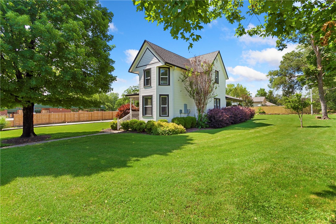 Looking for a home with historic Prairie Grove charm? This is the home you have been waiting for! The 3 bedroom 2 and a half bath home was originally constructed in 1916 and is a complete remodel. Walk inside from the from the front porch and you will find the original hardwood floors and original tin ceiling in the family room. Amenities, include granite countertops throughout, stainless steel appliances, spacious closets, and a cozy family room with gas log fireplace. The covered side patio is great for all of your outdoor entertaining needs. Detached 30x36 garage is insulated and heated with a full bath including tiled walk in shower. Go upstairs in the detached garage and you will discover a small room and an abundance of storage space. Home is walking distance to Prairie Groves historic downtown business district, local restaurants, and much more!