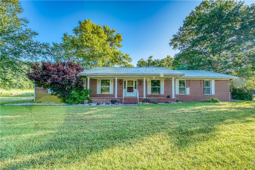 Osage, AR – 228 Acres with Creek Frontage & Custom Home! Discover a rare opportunity to own 228 breathtaking acres featuring over a mile of Osage Creek frontage! This exceptional property offers a mix of 91 wooded acres with approx. 62 acres of marketable timber and 137 acres of open pasture, perfect for cattle, horses, or recreation. The brick home boasts a metal roof and includes 2 bedrooms, 2 full baths, a 2-car attached garage, and a large sunroom warmed by a cozy propane stove. Enjoy the inviting ambiance of the native stone 2-sided fireplace that enhances both the living room and kitchen area. A whole-house Kohler generator provides peace of mind. Outbuildings include a 25x50 pole barn, 62x54 barn, and a 30x50 metal workshop, offering ample storage and workspace. Whether you're seeking a private retreat, working farm, or outdoor paradise, this property has it all!