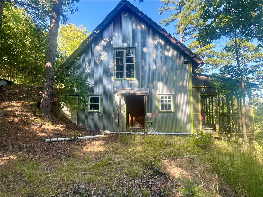 BEAVER LAKE AREA with lake frontage. Cabin is not finished so is being sold as-is, No disclosure. This property could be a great get away with a little bit of finishing work. Make the lay out of the interior to meet your needs. Finish it out and it would make a great weekend Airbnb. Has loft area which is the main Bedroom and claw bath tub. Could have 2nd bedroom upstairs also. The possibilities are unlimited with this unique cabin. A small walk to water but could do a trail as it is not that steep. Side by Side would be ideal for this property.