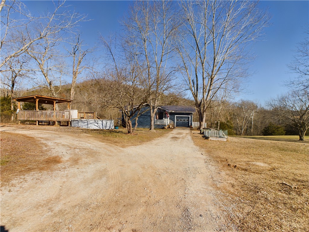 Beautiful setting for this 3 bedroom 2 bathroom home on 15.23 acres. Upstairs windows are new in 2022, new roof in 2019 and hardyboard siding. Above ground pool with updated sand filter and deck that has electricity. There is a tornado shelter in the basement. Barn has electric and shop has concrete floor and electric. There is a dog pen and a chicken coop. So much possibility. Land has access to wet weather creek that is the entire back side of the property.