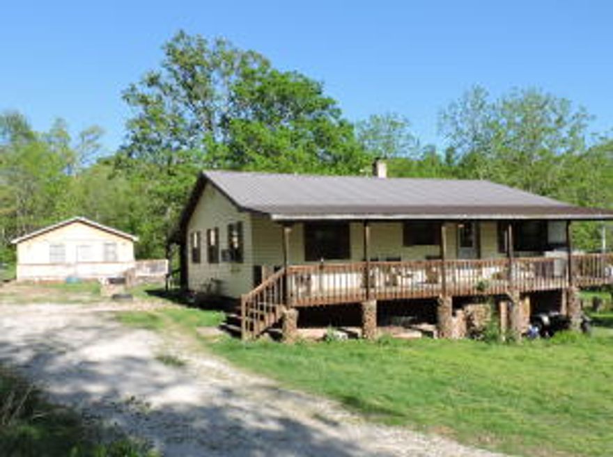 Two homes on 10 beautiful acres. 2 bedroom, 1 bath home with large living room. Large front & back porches, both covered. Unfinished basement. Hardwood floors. Newer cabinet doors & counter tops in kitchen. Brand new 1 bedroom, 1 bath cabin. Cedar exterior & metal roof. Deck on 2 sides. Nice metal barn plus a shop building. Older cabin used for storage. Huge garden spot. Food plot. 2 ponds. Seasonal creek.