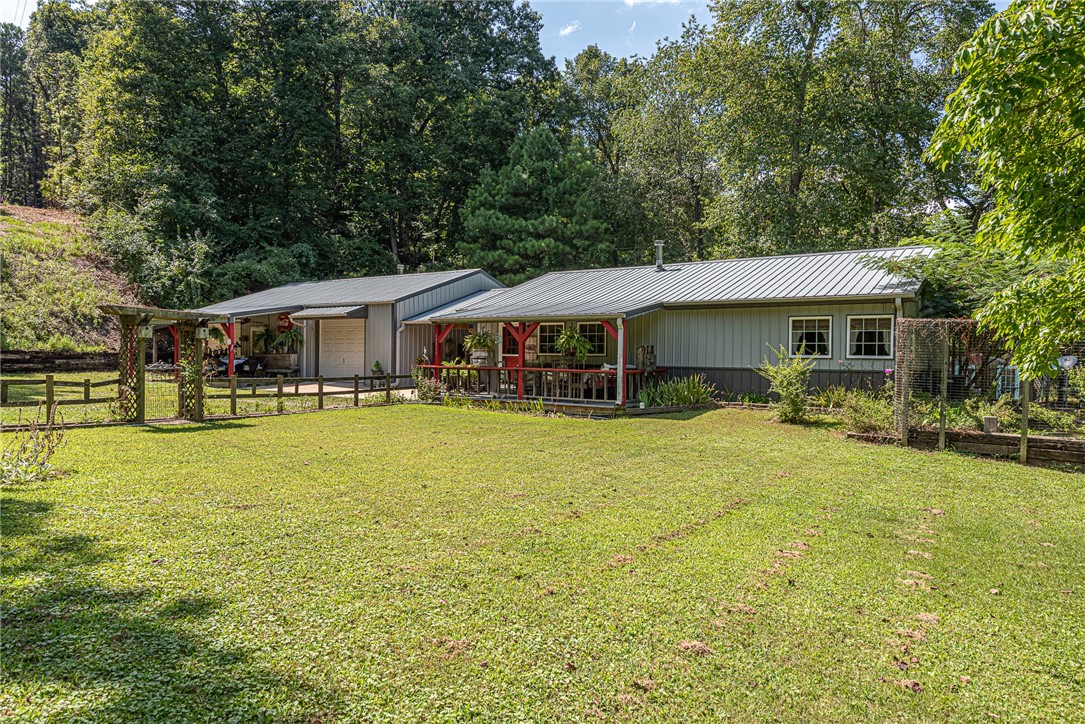 Home Sweet Home! This 2bd home on 1.99 ac +/- is a homesteaders dream! Located <7 mi from i-49, West Fayetteville, and Farmington! The homeās covered front porch overlooking the well maintained lawn leads you inside to the open concept living room with vaulted ceiling, laminate wood flrs, and L-shaped kitchen featuring beautiful cabinetry and stainless steel appliances with an eat-in dining room! 2 good size bedrooms with added laminate flooring! Full bathroom features large tiled shower and separate sink vanities! Head out through the breezeway to the 1200 SqFt shop w/ 2 garage door bays, electricity, plumbed for water, itās own wood stove, and insulated! Off the breezeway enjoy a wood pavilion perfect for enjoying your slice of paradise! With several garden plots and a green house this home is loaded with potential for your gardening dreams with room for chickens! Donāt miss out on this one of a kind home!