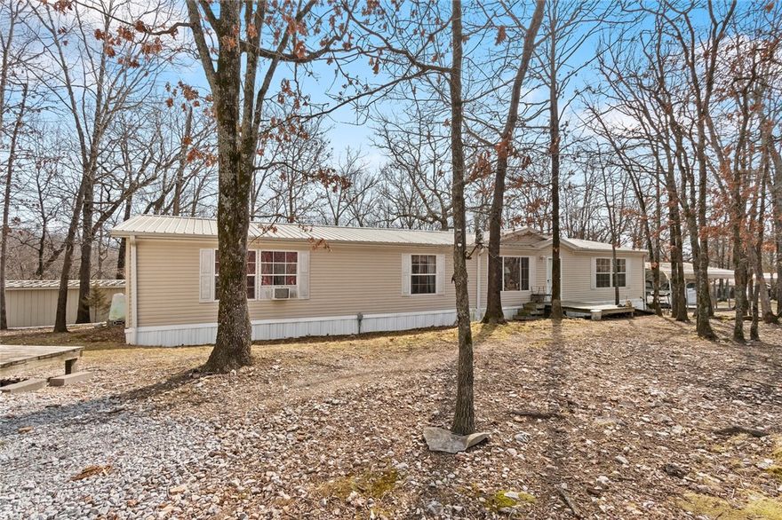 This property offers a doublewide (in immaculate condition), with 3/2.5 and extra living areas/office, fireplace (wood burning), open kitchen area with island, fireplace (wood stove), propane gas (owned propane tanks = 3) for cooking, everything is fed off a spring (with a system in place to include storage tanks), also offers a tiny house option for someone or outbuilding for a separate office/air bnb/or art studio/hobby area (this doesn't have septic in place), there are several out buildings, over 40 ac of woods and some cleared areas! This is a beautiful property close to the Illinois River and Kayak Park could be turned into an RV park?? Also, has a spring head on the property! There are several outbuildings: Doublewide 28x80, the tiny house (16x36) 576 SF, 22x32 shop w/ dirt floor, 20x25 carport, 2/x12 Storage Building, 14.5x27 well house (Spring water with storage tanks), 20x12 carport, 12x20 shop w/ cement.