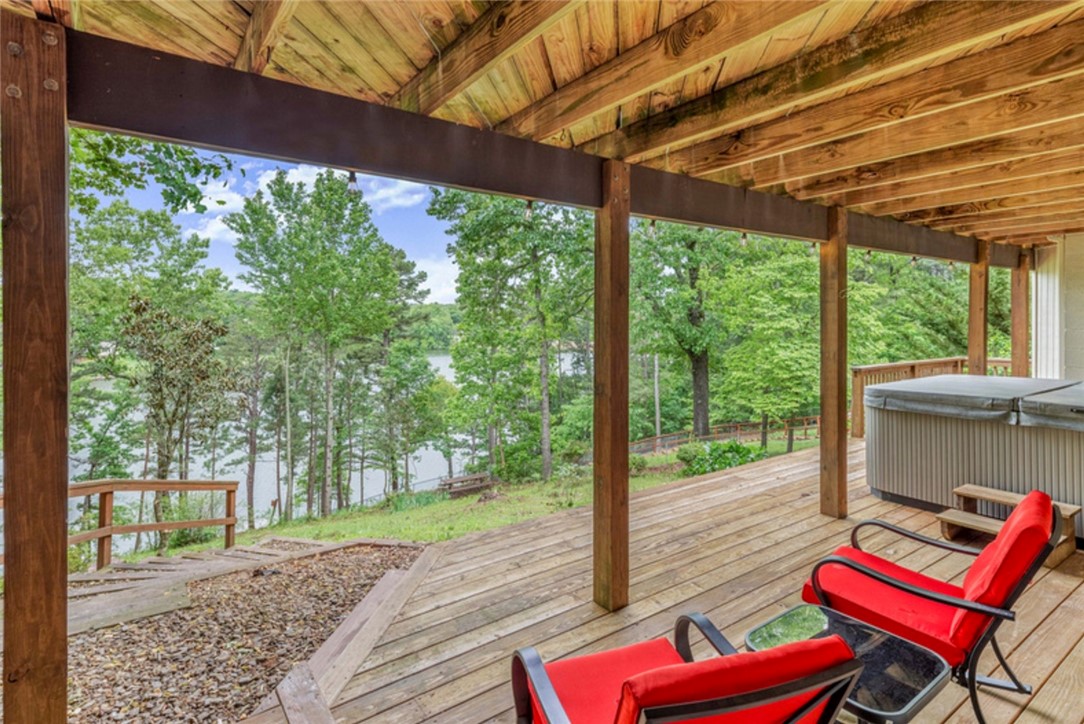 You will love this true lake-front property with a private dock. Currently a very popular, high producing short-term-rental, your new property is perfect for a family home or an investment. The wide open living area is perfect for hosting all your friends and family, and the party can spill out onto the expansive deck with amazing lake views. Your primary suite includes a private sunroom with access to the deck, perfect for morning coffee or an art space with excellent natural light. Two more sunny bedrooms, an updated full bath, half bath, plus a huge utility room with sink and tons of storage round out the main floor. In the fully finished, walk-out basement you'll find your in-law suite with kitchenette, large, sunny bedroom and huge closet that can have so many other uses, as well as full bath. Step outside to the covered deck with huge hot tub that conveys. Follow the steps to your private paddle boat/swimming dock. The paddle boat conveys as does the kayak storage. Schedule your tour of this lakefront beauty