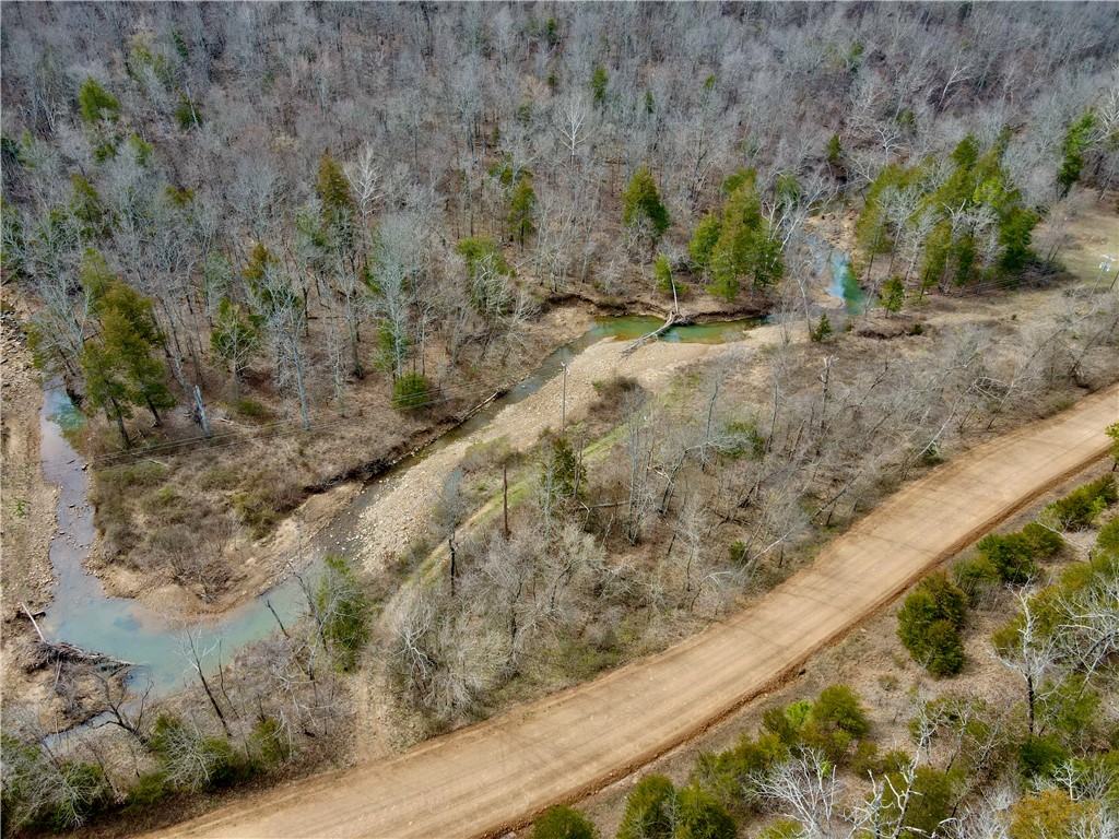 53+/- acre property, with Reed Creek frontage, a tranquil pond, and a natural spring. If youāre looking to build a peaceful retreat or a family homestead, this land offers multiple build sites both at the mountainās peak and its base, providing a scenic views and private setting. The rock bluffs add character to the landscape, making this property as picturesque as it is practical. Utilities are in place with electric on-site and Madison County water available at the road, simplifying development. Access is easy with gravel road frontage, ensuring year-round reachability while maintaining a sense of seclusion. Another unique feature is Reed creek running along the southern border. Ideally located just 9 miles from Huntsville, AR, and only an hour from Springdale, this property offers the perfect balance of seclusion and accessibility. Outdoor enthusiasts will appreciate the proximity to the Kings River, just 20 minutes away, and the iconic Buffalo River, a mere 38-minute drive.