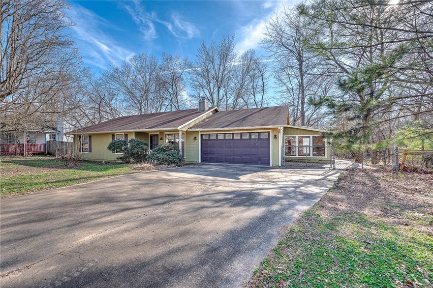 South Fayetteville Charmer on a quiet cul de sac! This 3 bedroom, 2 bathroom home is a beautiful open concept with a functional layout & so much potential - a diamond in the rough, awaiting your personal touches! Huge living room with a wood burning stove & tons of natural light streaming in from the south facing bay window in the dining nook. Spacious kitchen, perfect for entertaining, with lots of counter space & storage. Primary suite has a walk-in closet & private full bathroom. 2 additional bedrooms share a recently remodeled bathroom. 2 car garage has an attached room, perfect for a hobby space, shop or greenhouse. Covered back patio overlooks the large peaceful backyard with mature trees, a fire pit and creek access at the back of the .32 acre property. Prime location - 1 mile to both I-49 and S. School Ave provides easy access to all of NWA. A short walk/bike to the Greenway trail connects the UofA, Baum Stadium, Southyard, Downtown, & multiple parks, including Kessler via trail!  Come see this home today!