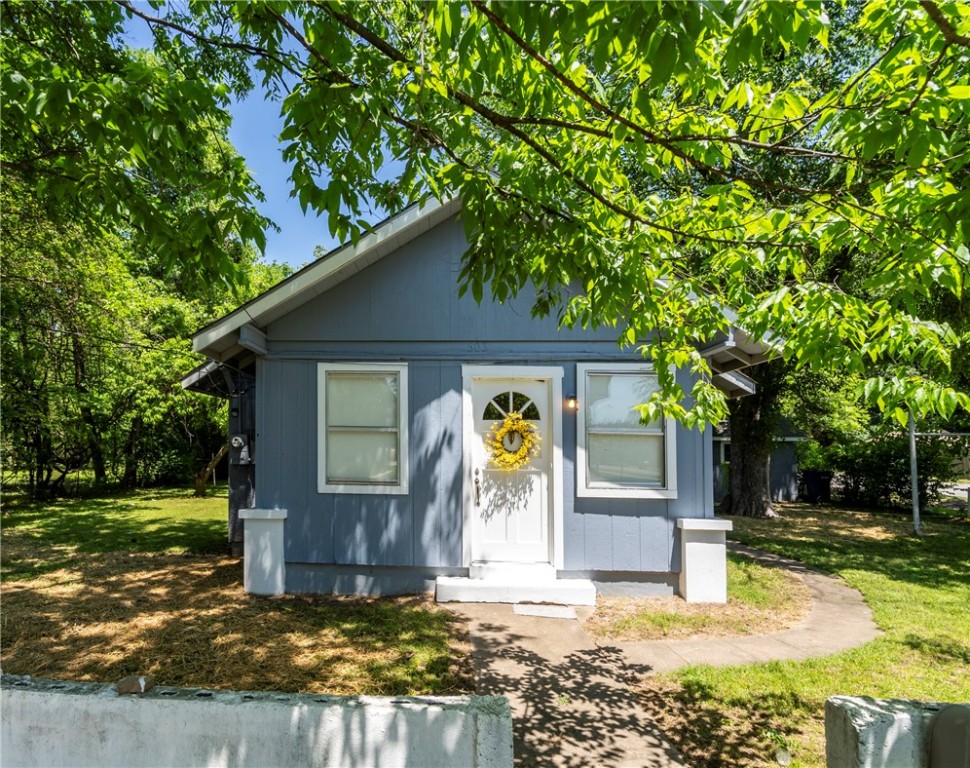 Great location! Close to everything-downtown Siloam Springs! 2 bedroom, 1 bath home located on a corner lot. New carpet, laminate flooring, and ceiling fans. Central HVAC. Water lines replaced under the home with PEX. 2 car carport. Storage building beside the house has concrete floors and electric to it-could easily be converted into a home office or use it as a workshop! Covered side porch and large yard with mature trees.