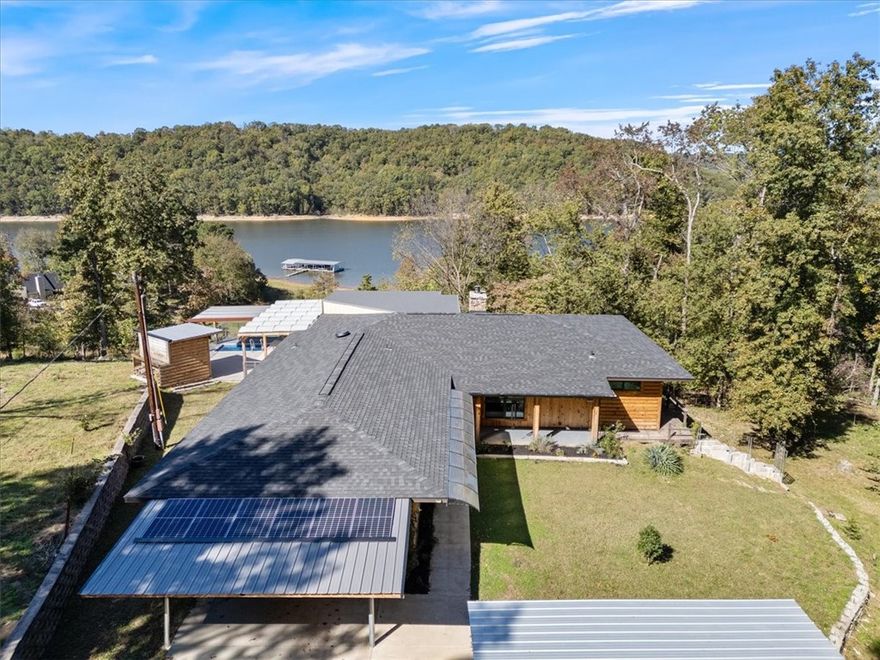 Don't miss out on this lakehome, priced below appraised value! Enjoy stunning lake views from this beautifully updated 2 BR / 2 BA home on a private 1-acre lot. Modern design meets rustic charm with pine log siding, open-concept living, and 2022 upgrades including new roof, HVAC, windows, water heaters, kitchen appliances, smart toilets, and additional storage beneath the home. Relax in the 1,500-gallon plunge pool (new pump) overlooking the lake or take advantage of six solar panels powering a backup system that runs portions of the home for 2–3 days. Added carport space, privacy, and efficient living make this home truly special. Refrigerator, washer, and dryer convey. Listed below appraisal value—don’t miss this unique lakeside retreat!