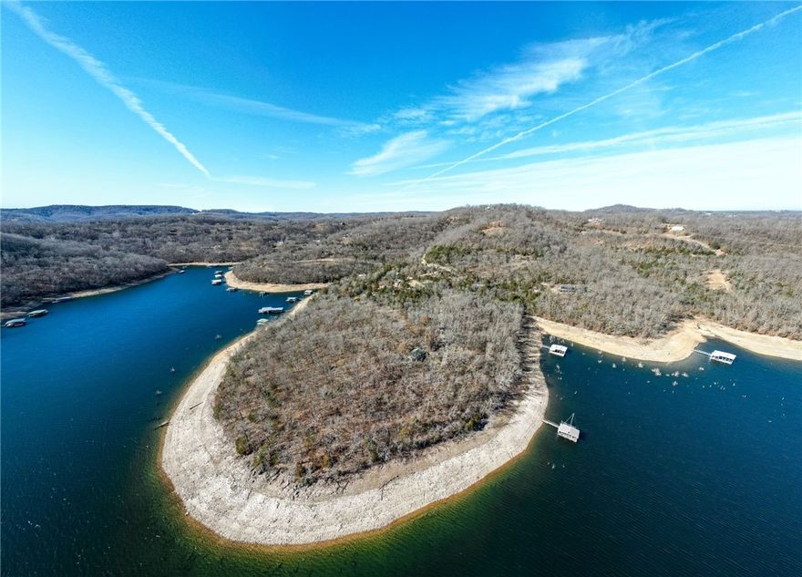An exceptional opportunity to own 5.77 acres of prime lakefront on Beaver Lake, featuring a private 2 slip dock (10x24 slips). This extremely unique parcel of lake front LEVEL land offers expansive views, peaceful surroundings, and ample space for your custom lake home, guest house, and outdoor entertaining areas. The peninsula of more than 1,300 feet of lake front shoreline-an increasingly rare find, offers an ideal setting with its current cabin for weekend get a ways, while you construct your Beaver Lake dream home. Enjoy direct easy shoreline access to the private dock with lift, solar power, covered swim deck, and 2 storage lockers. This generous acreage provides rare privacy while still capturing the natural beauty and lifestyle Beaver Lake is known for. Whether envisioned as a luxury retreat or a legacy property, this lakefront setting delivers the ultimate blend of space, scenery, and lake access. There is an 8x20 steel container located on parcel ID # 15-03837-002 utilized for storage. 22288 Sunrise Cove.