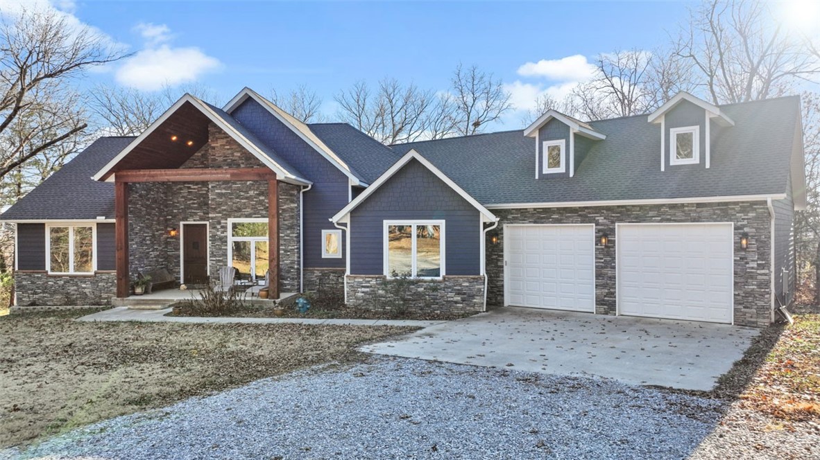 Enjoy views of Mt Sequoyah Lake on the way to your home that's nestled in the woods on 3 acres. The kitchen is open to the living room and has double ovens, a large island, and a pantry with additional counter space. Enjoy the sunsets on the back porch while watching deer and other wildlife while warming up by the propane fireplace. The upstairs oversized bonus room has a pool table that conveys, a half bath, and a private deck overlooking the gorgeous woods. Don't miss the gun safe room in the large garage! Previous owner used it as a reload room. Not only can you park your cars in the garage, but there is ample room for a workshop. With a driveway like the one here, you can't run out of parking spaces! The perfect balance of being minutes from town but feeling miles away at the same time.