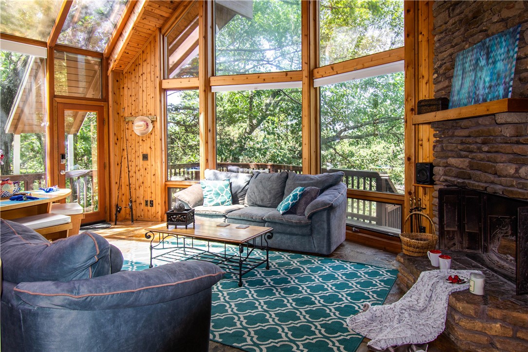 Escape to your new Lost Bridge lake home or Airbnb water front paradise on Beaver Lake! Enjoy stunning views, fishing, kayaking, or simply relaxing all just steps away from the waters edge. This cozy gingerbread cabin features a spacious living area, fireplace, a fully equipped kitchen, comfortable bedrooms, sauna and 6 person hot tub with an outdoor shower. This very profitable Airbnb with 69k ROI in 2024, sleeps 10 and just had a kitchen remodel 3 years ago with stainless steel appliances. Not only does it have cedar throughout the home, it has skylights in the living and dining room to enhance the stone flooring and cabin features. So, now can you imagine your evenings on one of the two decks, or sitting by the fire pit enjoying the lake breeze and breathtaking sunsets? With a community pool, boat ramp, tennis courts and hiking trails all near the state park? This Stitt built home was designed to minimize environmental impact and promote a healthier lifestyle. It's time to make waves and host your next guest.