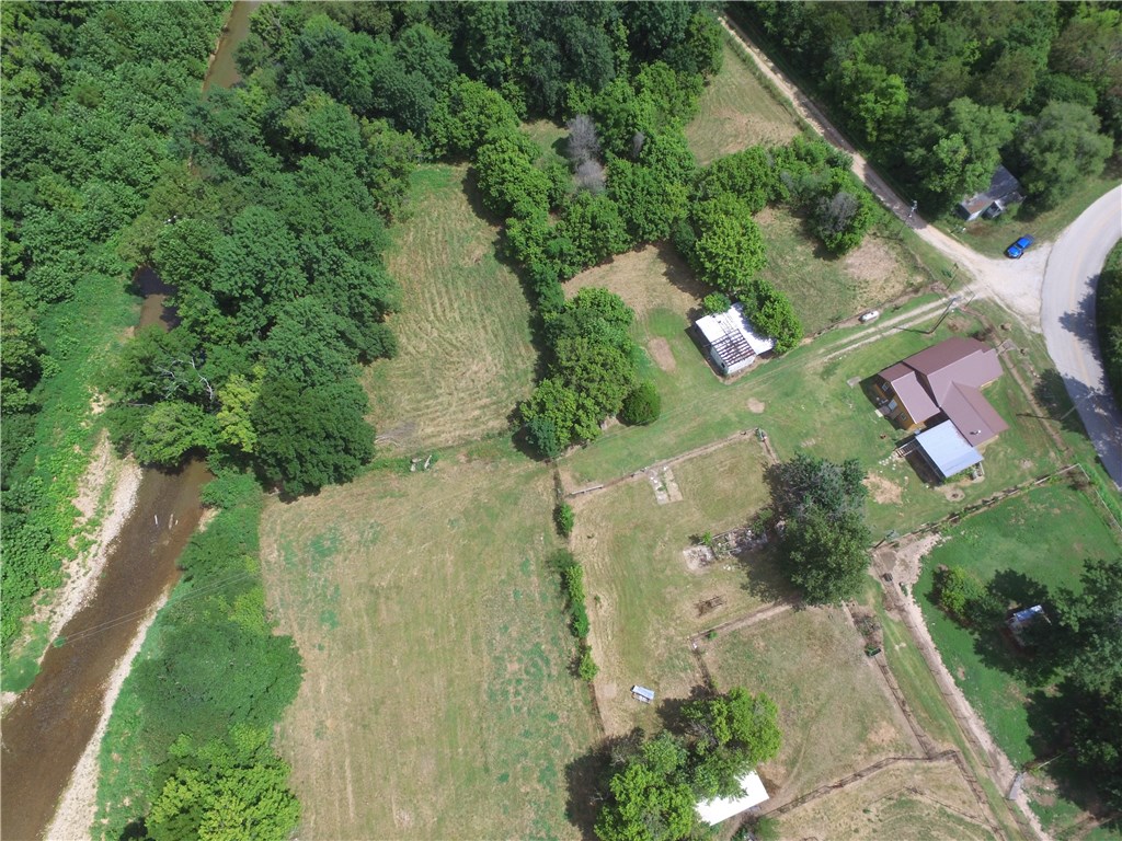Renovated Home on 3.72 acres surveyed. 1768 sq.ft. on main level with additional 480 sq.ft. master suit in basement level. Total 2,248 combined. Live Edge Spruce wood exterior, metal roof, large covered deck, Hickory Cabinets, stainless steel appliances, wood stove in family room, 3BR, 2.5BA, with utility, large mud room, additional room could be office, living room, dinning room. Tile & Vinyl Plank flooring, fenced into 4 pastures with lots of pipe fence for horses, fronts Long Creek. Located on paved road close to Branson MO & Table Rock Lake, would make a nice place for a horse.