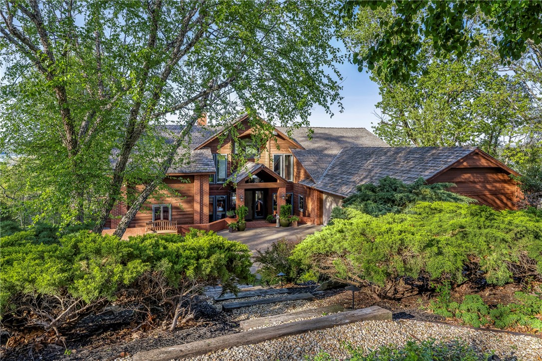 Prepare to be amazed by this stunning lakeview home with panoramic, year-round water views from every room. Enjoy a 180-degree view from the expansive deck and dramatic 36-foot ceilings in the living room, flooded with natural light through a wall of glass.
Can walk or drive to your private co-owned dock, lift swim deck and locker. This cedar contemporary blends luxury living with easy entertaining. The island kitchen is stylish and functional, and the spacious family room includes a custom media wall and wet bar. Lots of generous storage and thoughtful extras.