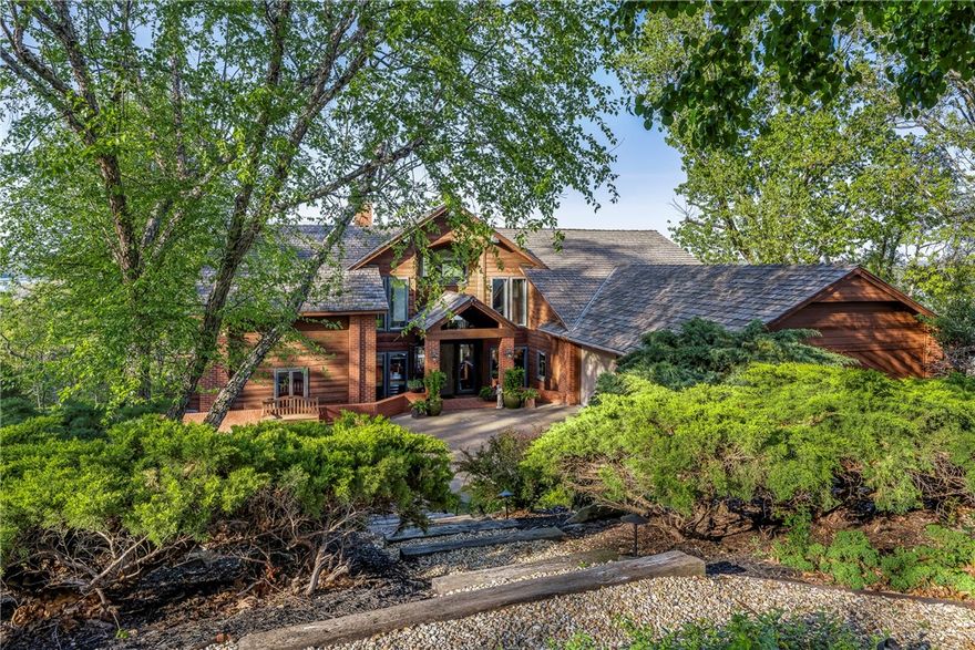 Prepare to be amazed by this stunning lakeview home with panoramic, year-round water views from every room. Enjoy a 180-degree view from the expansive deck and dramatic 36-foot ceilings in the living room, flooded with natural light through a wall of glass.
Can walk or drive to your private co-owned dock, lift swim deck and locker. This cedar contemporary blends luxury living with easy entertaining. The island kitchen is stylish and functional, and the spacious family room includes a custom media wall and wet bar.  Lots of generous storage and thoughtful extras.