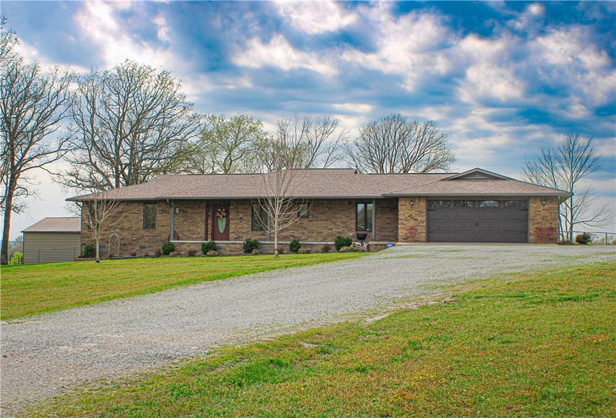 Sitting just 4 miles north of Berryville is where you will find this stunning acreage and brick home. Imagine yourself taking in the sunset over your own slice of heaven every evening as you kick back on your screened in back porch. Fully fenced 66 acres of gently rolling pasture with cross fences, a corral, 2 ponds, and the ability to produce 300+ bales of hay, annually.  You will fall in love with the warmth of the beautiful brick home. This home was built with detail in mind and offers 3 bedrooms, 2 baths, oak kitchen cabinets with granite countertops, wainscoting, large primary bedroom with walk in closets and a spacious primary bathroom with jetted tub and makeup vanity, tiled walk-in shower in guest bathroom, a large laundry/mudroom, 2 car garage with built in storage, a cellar accessed via the primary bedroom, wired for whole a house generator, secondary heating via a hardy stove, and more! Well water with softener. Rural water available at road, tap paid.  Come take a look and you will never want to leave!