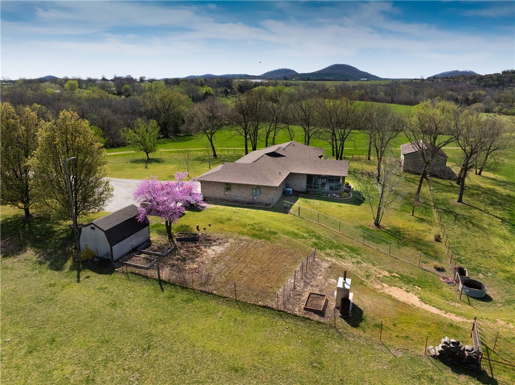 Sitting just 4 miles north of Berryville is where you will find this stunning acreage and brick home. Imagine yourself taking in the sunset over your own slice of heaven every evening as you kick back on your screened in back porch. Fully fenced 66 acres of gently rolling pasture with cross fences, a corral, 2 ponds, and the ability to produce 300+ bales of hay, annually. You will fall in love with the warmth of the beautiful brick home. This home was built with detail in mind and offers 3 bedrooms, 2 baths, oak kitchen cabinets with granite countertops, wainscoting, large primary bedroom with walk in closets and a spacious primary bathroom with jetted tub and makeup vanity, tiled walk-in shower in guest bathroom, a large laundry/mudroom, 2 car garage with built in storage, a cellar accessed via the primary bedroom, wired for whole a house generator, secondary heating via a hardy stove, and more! Well water with softener. Rural water available at road, tap paid. Come take a look and you will never want to leave!