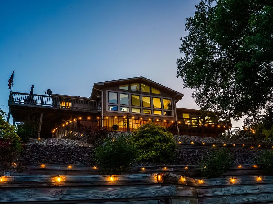 Experience lakefront living in this 3bd/3bath with breathtaking view of beautiful lake Lomond, generous living spaces, & premium amenities. Main level features inviting living room with fireplace, formal dining, wet bar, & sunroom showcasing panoramic lake views. The well equipped kitchen includes range, double oven, dishwasher, microwave, & disposal. The lower level offers a private bedroom & bath, spacious living area with cozy fireplace, second kitchen, & heated/cooled bonus room perfect for a home gym, office, or hobby space. Step outside to a large covered patio with 2 ceiling fans, creating the perfect setting for relaxation. Enjoy an easy stroll down to the covered boat slip, complete w/boat lift, moss back fishing structure around & under dock, an underwater dock light, everything you need to catch your limit from the comfort of your own private dock. Car enthusiast will appreciate the oversized two-car garage, offering ample space. Recently installed garage doors with ultra-quiet openers add value.