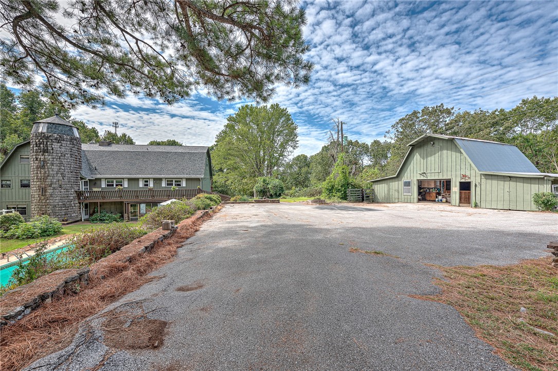 Home sits on two parcels of land that add up to 6.5 total acres, gunite pool, three-car garage, horse barn, two heat pumps. Two spacious living rooms, two fully equipped kitchens, library, updated bathrooms with jetted tub, updated flooring in kitchen, living room, and hobby room, along with expansive outdoor spaces. RV parking with 50-amp plug. Located just three miles from Horseshoe Bend Marina and Campground and a quick five-mile drive to downtown Rogers. Private boat slip in small community dock available to purchase with house. Motivated Sellers.