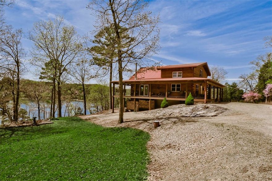 Cozy Log Cabin with over a half mile of lakefront with 4 slip dock on 75 Acres. Unrestricted property offers development potential. Home has easy access to the lake with wonderful views. 3 bedroom 3 bath, 2464 sq. ft. with great lake views from the wrap around porches. Vaulted ceiling in the great room with open floor plan make this a perfect lake home. Property has large shed, RV parking with water/sewer/electric hookups. 3825 Watt Solar System, wood burning stove on lower level and propane stove in great room. Beautiful setting with limestone bluffs and gated entry. Easy drive down access to the boat dock.