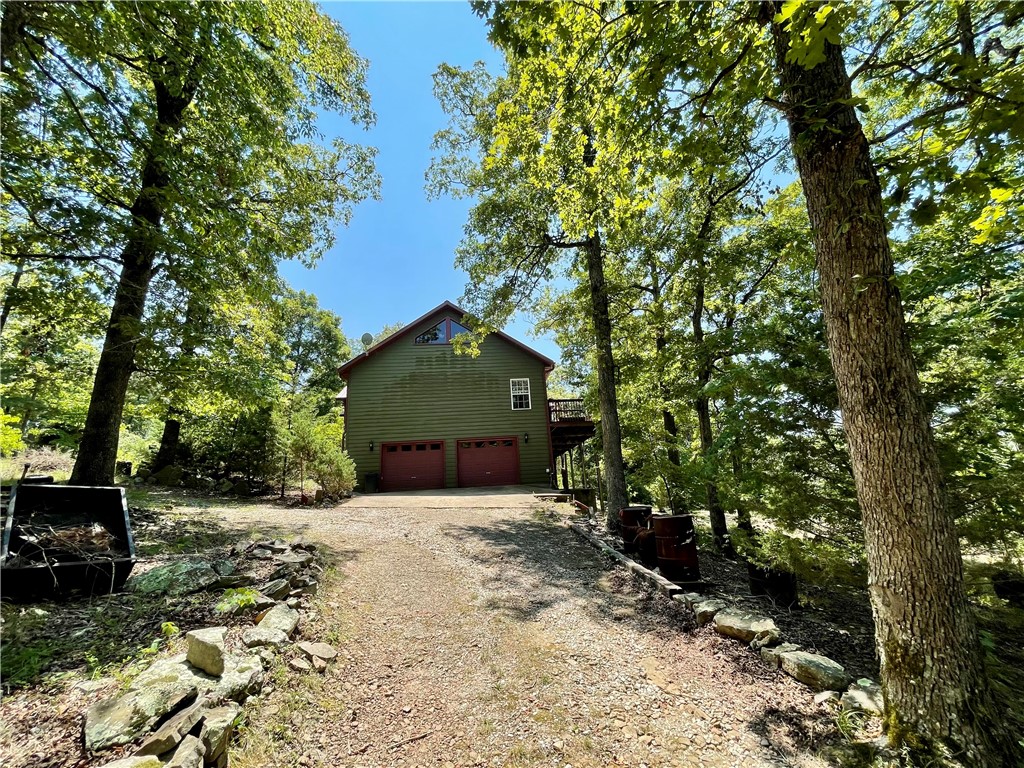 This custom home, built in 2006, is situated on 11.5 secluded wooded acres with a natural spring flows year round, offering views for miles from its back deck. The main floor comprises 3bed/2.5baths including one room currently used as an office with a half bath. A guest bedroom features its own private bath, while the primary bedroom boasts a jacuzzi bath, separate walk-in shower, and double vanity. A 492 sq ft basement includes 1bed/1bath & office space/flex room. 2 car garage with ample storage space. A new generator providing emergency backup power. The property also features a 610 ft well with a new pump and tiles, a new double oven in the kitchen, a separate water heater for the kitchen, complemented by an 80-gallon water heater for the rest of the home. A 12x12 storage building and Ozarks Go Fiber Optic internet and cable services available. With its serene and private setting, this home offers an ideal escape, located 15-20 minute drive from Huntsville or Elkins, AR with easy access to all of NW AR.