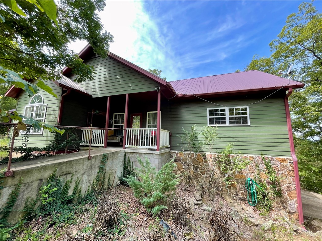 11.5 acres! This custom home, built in 2006, situated on secluded wooded acres with a natural spring flows year round, offering views for miles from its back deck. The main floor comprises 3bed/2.5baths including one room currently used as an office with a half bath. A guest bedroom features its own private bath, while the primary bedroom boasts a jacuzzi bath, separate walk-in shower, and double vanity. A 492 sq ft basement includes 1bath & office/flex room.13x16 storm shelter used as bedroom.Steel fire door. A new generator providing emergency backup power. The property also features a 610 ft well with a new pump and tiles, a new double oven in the kitchen, a separate water heater for the kitchen, complemented by an 80-gallon water heater for the rest of the home. A 12x12 storage building and Ozarks Go Fiber Optic internet and cable services available. With its serene and private setting, this home offers an ideal escape, located 15-20 minute drive from Huntsville or Elkins, AR with easy access to all of NW AR.