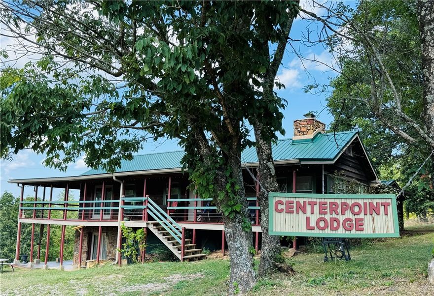Bring your family and business plan—Centerpoint Lodge offers both! Set on 4.11 acres at Hwy 43 & Fire Tower Rd, directly across from the Centerpoint Trailhead, this 1976 lodge blends comfortable living with multiple income streams. The main level features the owner’s quarters with a large kitchen, dining area, rock fireplace, and wraparound porch. The walkout basement includes two guest suites with kitchens, full baths, and queen beds. Additional lodging offers hostel-style rooms with shared baths, private suites, and a separate cabin/bunkhouse that sleeps 6–8 with its own kitchen and bath. Outdoors, guests enjoy RV hookups (water/sewer), a shower house, and horse pens for trail riders. A rare chance to live where you work—residence, retreat, and revenue in one Ozark location. Owner financing available with a considerable down payment. Listed as commercial property MLS#1318503.  Listed MLS 1319583 with additional 5AC