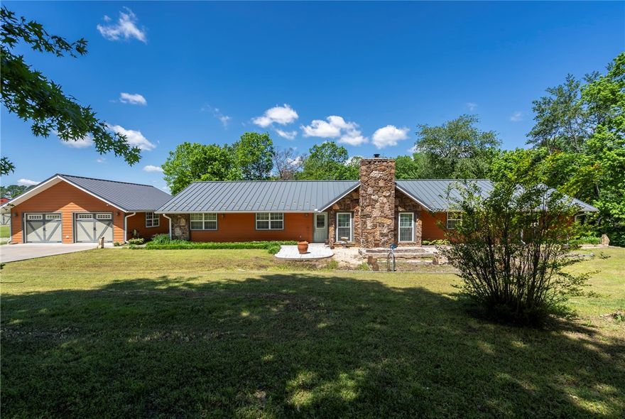 Welcome to your dream property located minutes from town on 5 spacious acres. This home offers comfort and functionality with a standing seam metal room, new septic system in 2019 offering peace of mind. The kitchen is equipped with built-in oven, gas cooktop range, trash compactor, with plenty of cabinet space for storage. Enjoy the dedicated spaces like the sunroom, private office and media closet for your home office or entertainment needs. Two zone on-demand water heaters ensure efficient and endless hot water. The outdoor space is just as impressive, with an entertainment ready porch and pavilion ideal for gatherings. The 16X20 barn with electric offers extra storage or workshop potential, while the 2-car garage is plumbed for compressed air- perfect for hobbyists or mechanics. This property offers space, privacy and versatility that is a rare find.