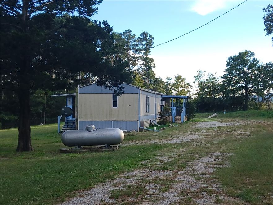 Single Wide Mobile home on 1.6 acres of land offers 3 bedrooms, 2 baths and an enclosed porch. Handicap accessibility to the the front porch by way of a ramp. Unique opportunity to own a buried school bus, previously used as an underground storm shelter compete with electric. Reno the Mobile for investment or remove it and build your dream home. Country Living, Nice location at the Stateline with less than 1/4 mile of gravel road to the house. less than 10 minutes to the lake- Sold AS IS - Mobile does have clear title.