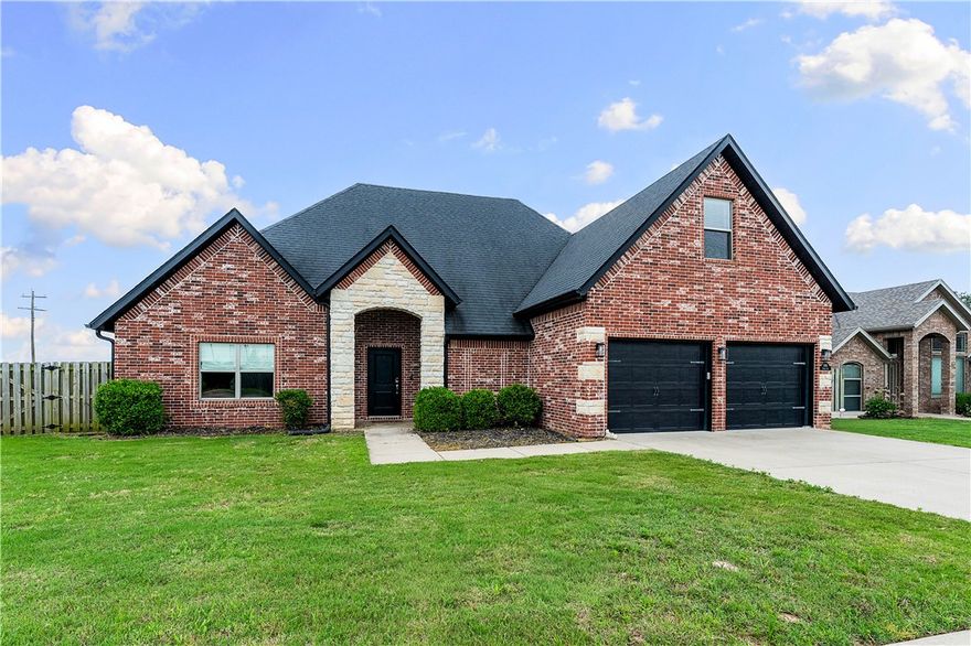 Located in the highly sought-after Sunrise Ridge subdivision, this stunning all brick and stone home offers style, comfort, and convenience! Situated on a spacious 0.32-acre corner lot with a huge flat, fully fenced backyard with room for a pool. The open floor plan features wood-look tile flooring throughout the main level, abundant natural light, and a modern rectangular gas fireplace as the centerpiece of the living room. The kitchen is perfect for entertaining with granite countertops, stainless steel appliances, pantry, gas range, and designer lighting. Main level includes 3 spacious bedrooms and 2 full bathrooms, including a luxurious primary suite with double vanity, fully tiled walk-in shower, jetted tub, enclosed toilet area, and oversized walk-in closet. Upstairs offers a large bonus room with half bath. Enjoy the covered patio, outdoor fireplace, and custom gas fire pit. Close to Bentonville West schools, parks, trails, shopping, and dining!